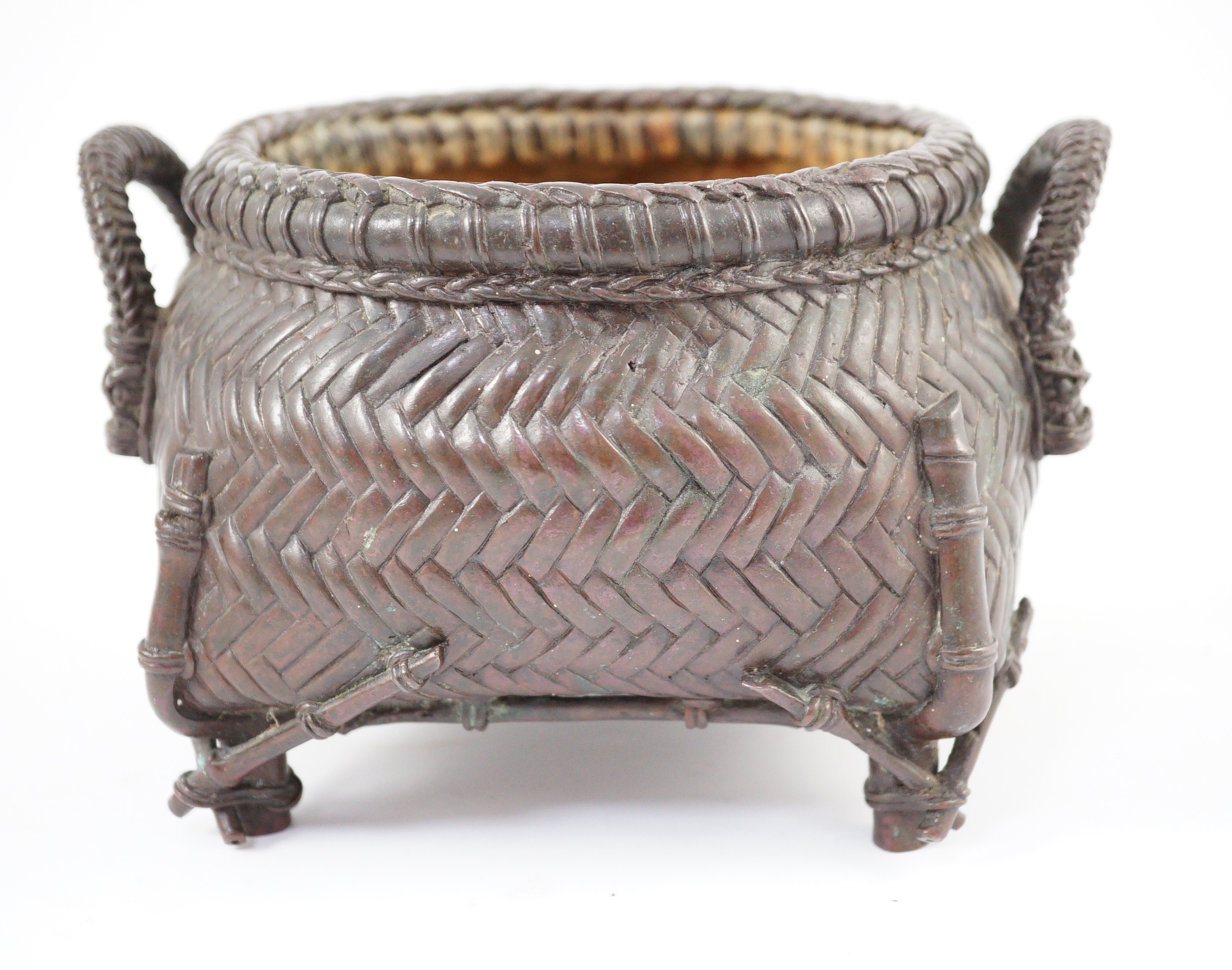 A Japanese bronze koro, 19th century, cast in imitation of a takezaiku bamboo basket, applied with a pair of looped handles, on four bamboo shaped feet, 17.5cm wide